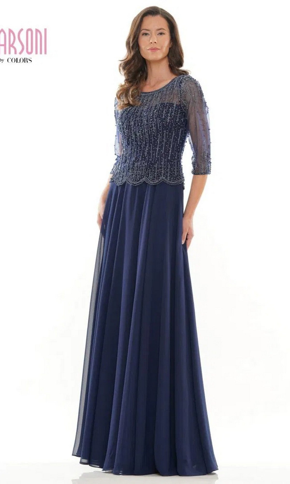 A woman models the Marsoni M312 long formal dress in navy, featuring a beaded bodice, sheer sleeves, and an elegant a-line skirt against a plain background.